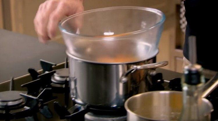 Punem gălbenușurile de ou într-un bol, adăugăm oțet de vin la ele și punem totul într-o baie de apă.