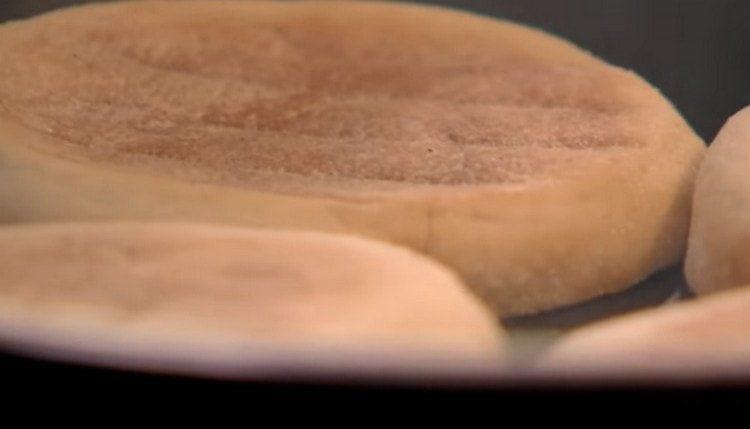 După slănină, prăjiți chiflele tăiate în jumătate într-o tigaie.