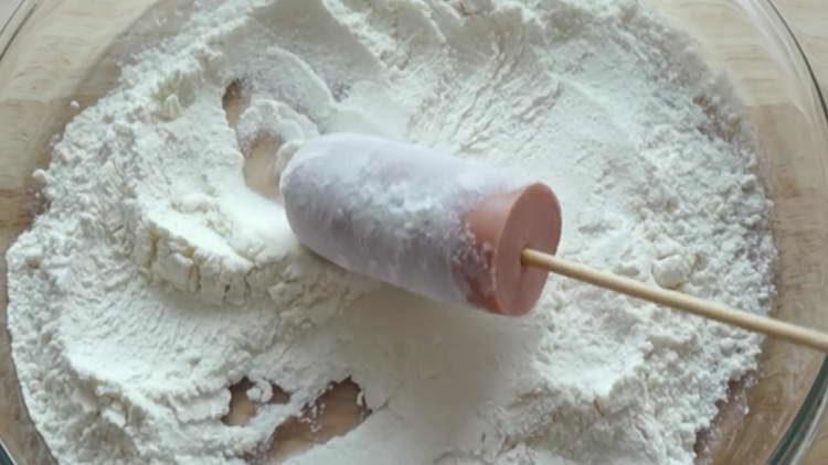 Würste in Mehl einwickeln