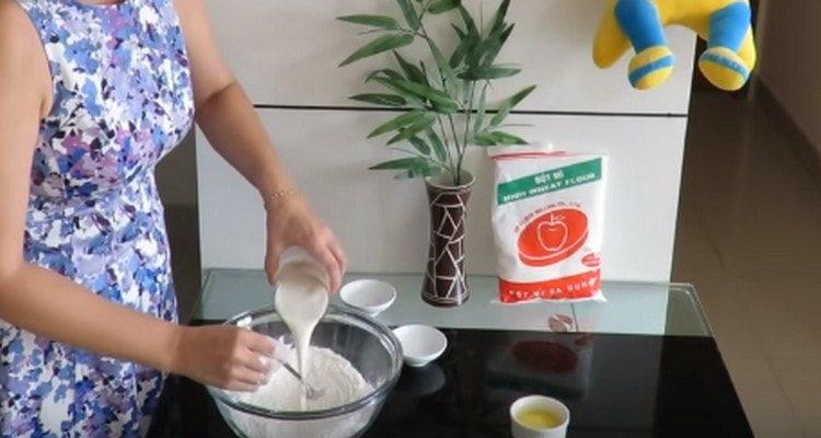 Verter la masa en la harina tamizada, mezclar.