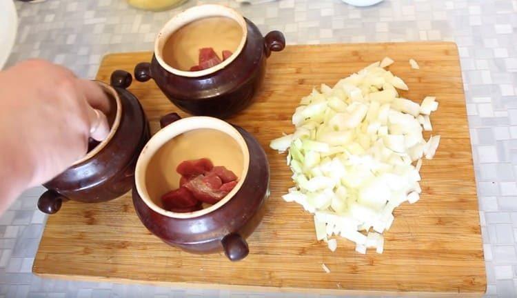 Слагаме месото в саксиите.