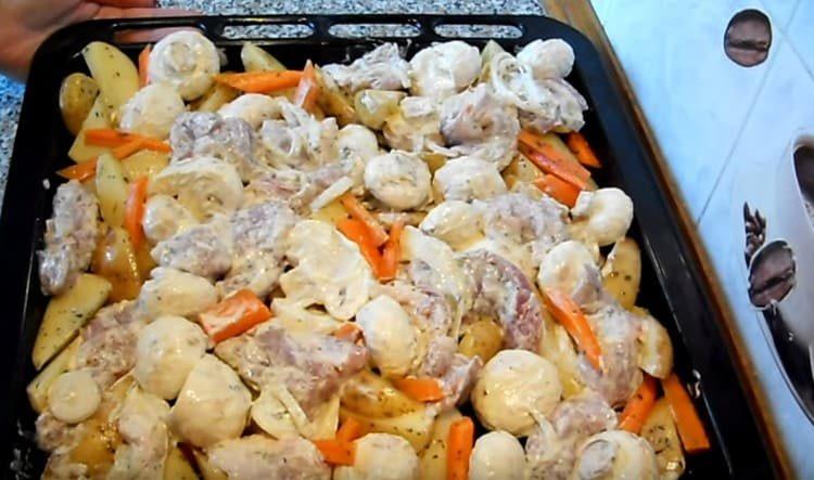 Oven på kartoflerne fordeler vi kød med løg, svampe.