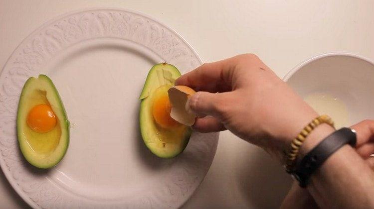 În fiecare jumătate a fructului, bateți oul.