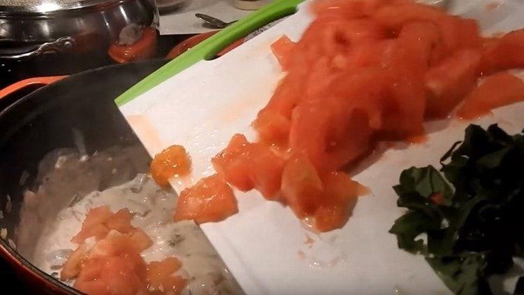 Agregue los tomates picados y la albahaca a la sartén.