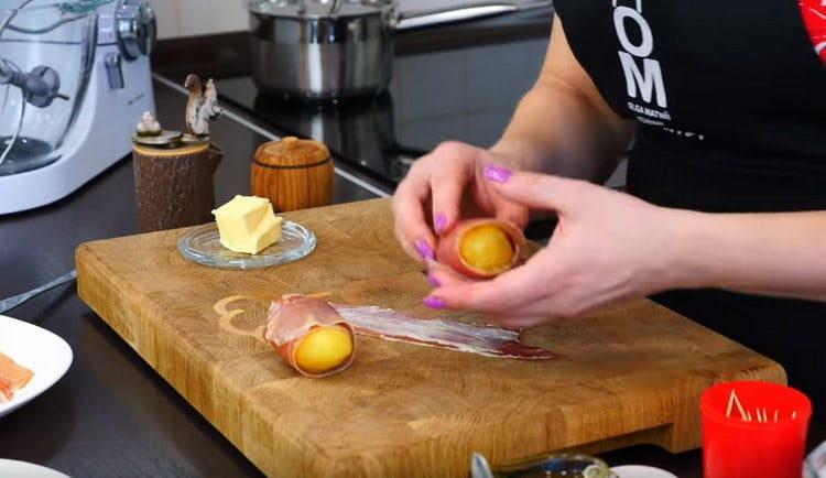 Увийте картофите в бекон.