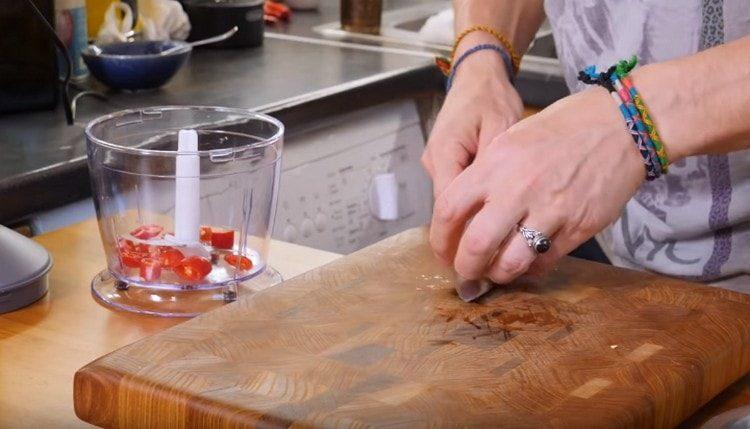 Jemně nasekejte česnek, feferonku a rozetřete do mísy mixéru.