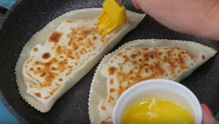 Обърнете питките от другата страна и веднага намажете с разтопено масло.