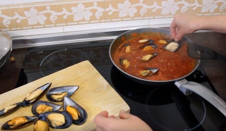 Extendemos los mejillones en salsa de tomate y cocinamos a fuego lento durante unos minutos más debajo de la tapa.