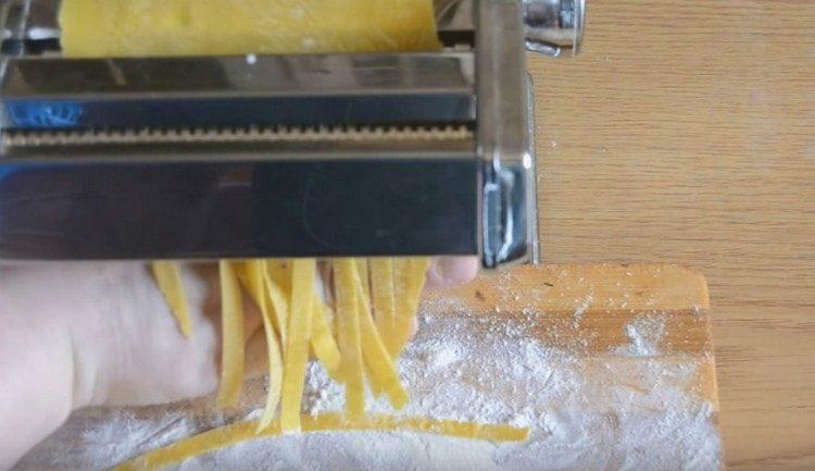 Con un cortador de fideos o un cuchillo, corta los fideos.