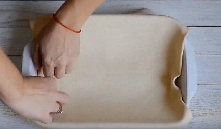 Разточете тестото и го сложете в намазнена форма.